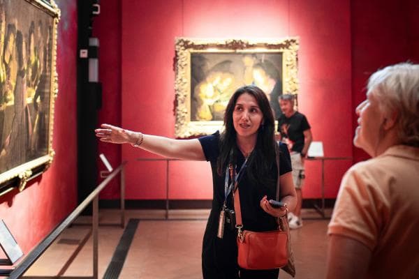 Tour guide indicates artwork in the Uffizi Gallery.