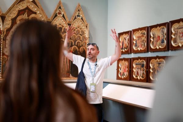Guida turistica che spiega a un gruppo le opere nella Sala dei Giotteschi