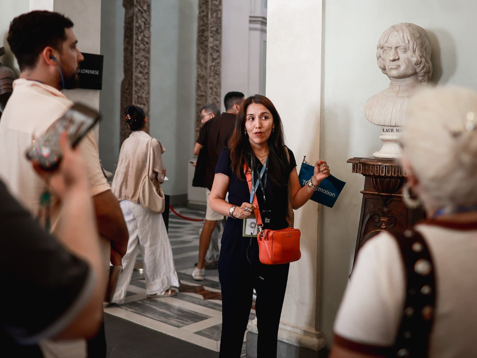 Tour guide speaking to a group of visitors inside the Uffizi Gallery.