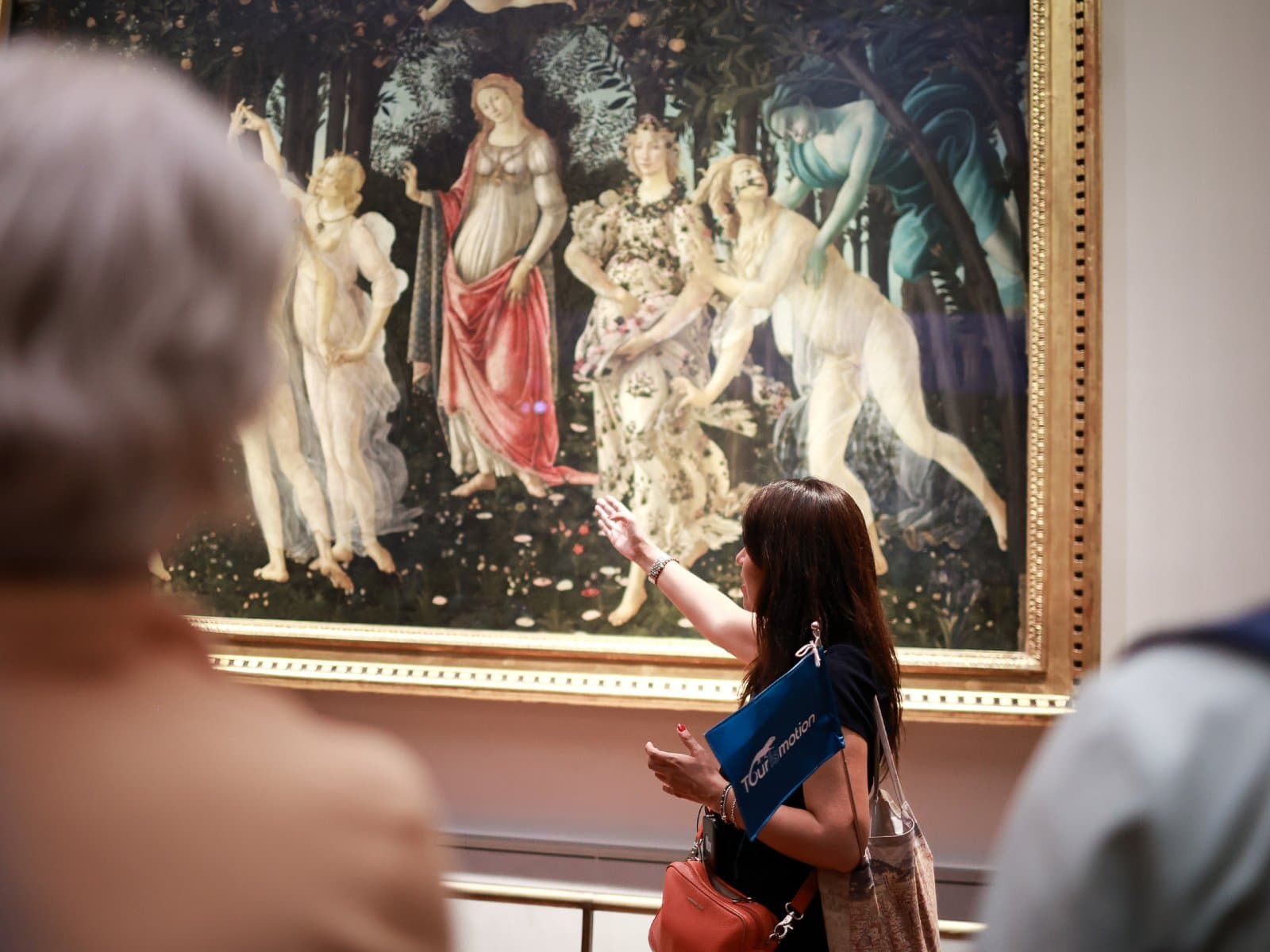 Expert guide describes Botticelli's Primavera to a group of visitors at the Uffizi Gallery.