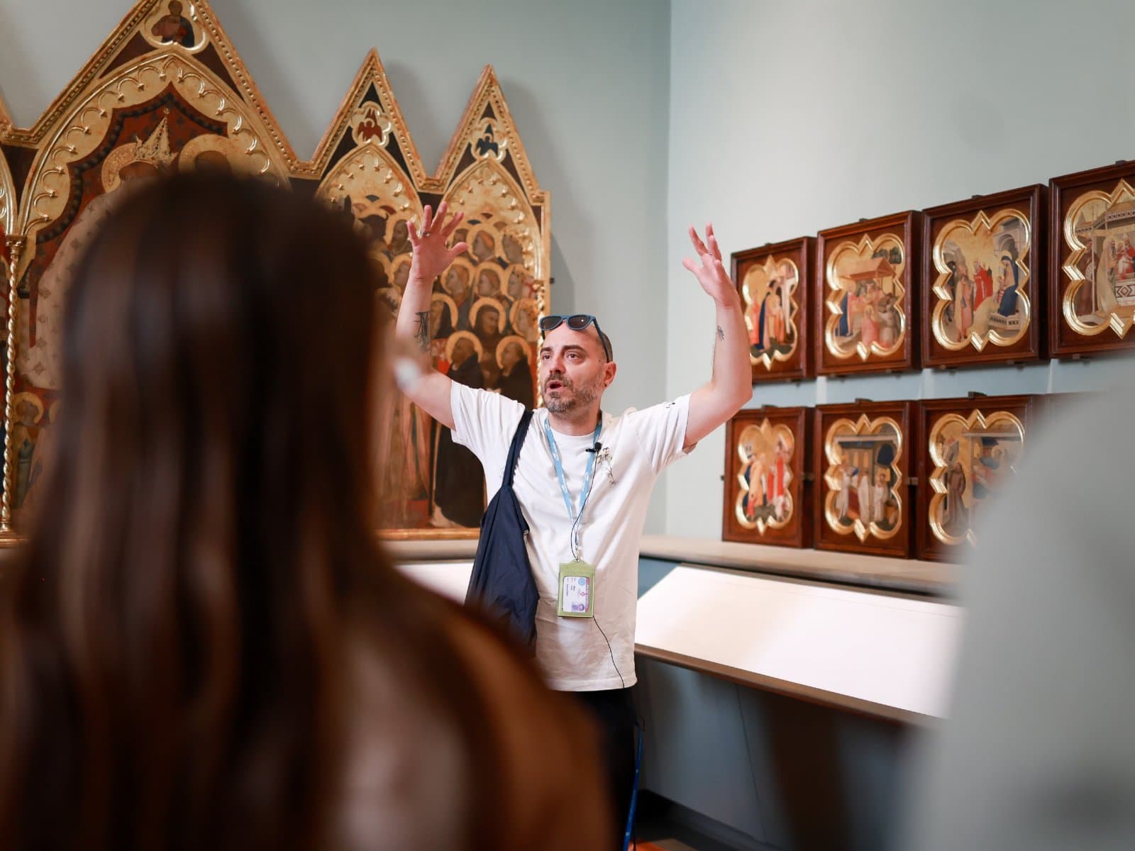 Tour guide explaining works in the Giotto Hall to a group