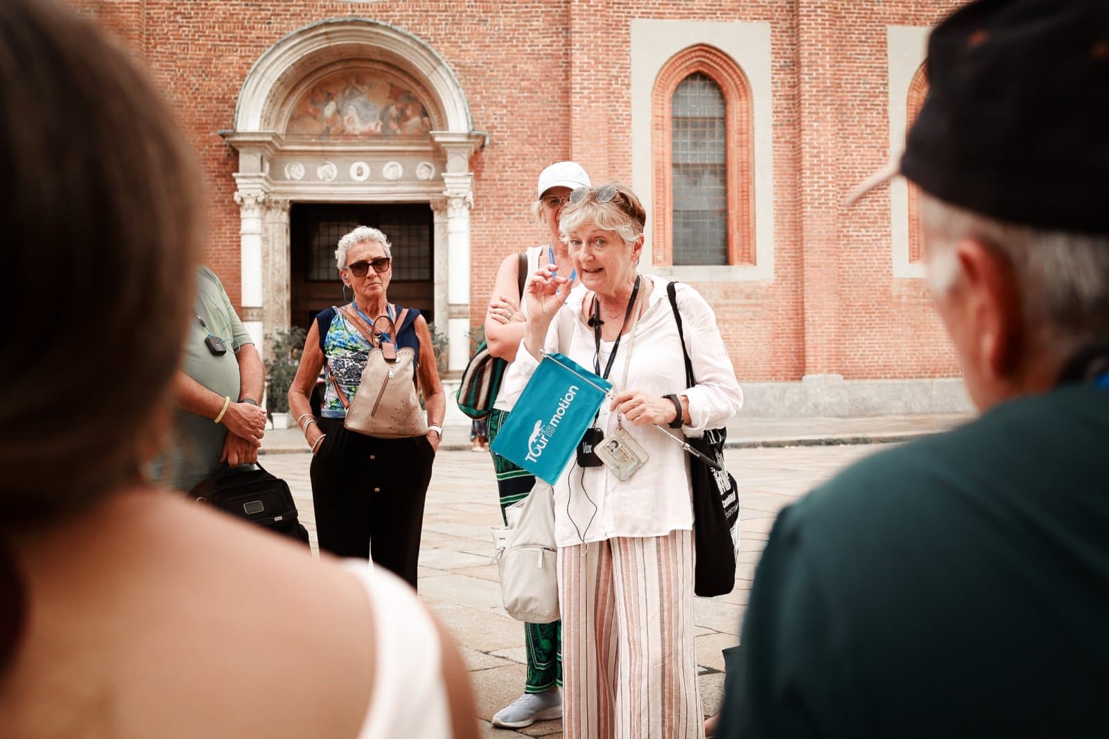 Guía turística con grupo de turistas frente a Santa Maria delle Grazie en Milán