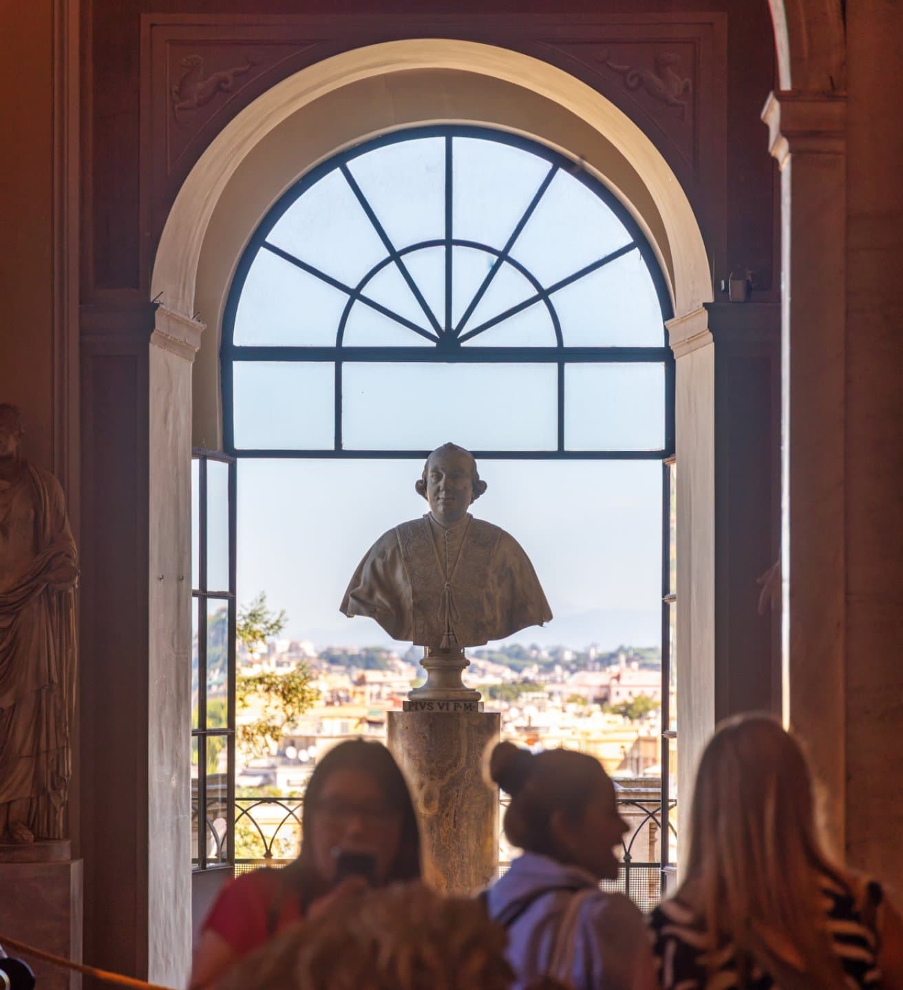 Bust of Pope Pius VI in front of a panoramic window of the Vatican Museums