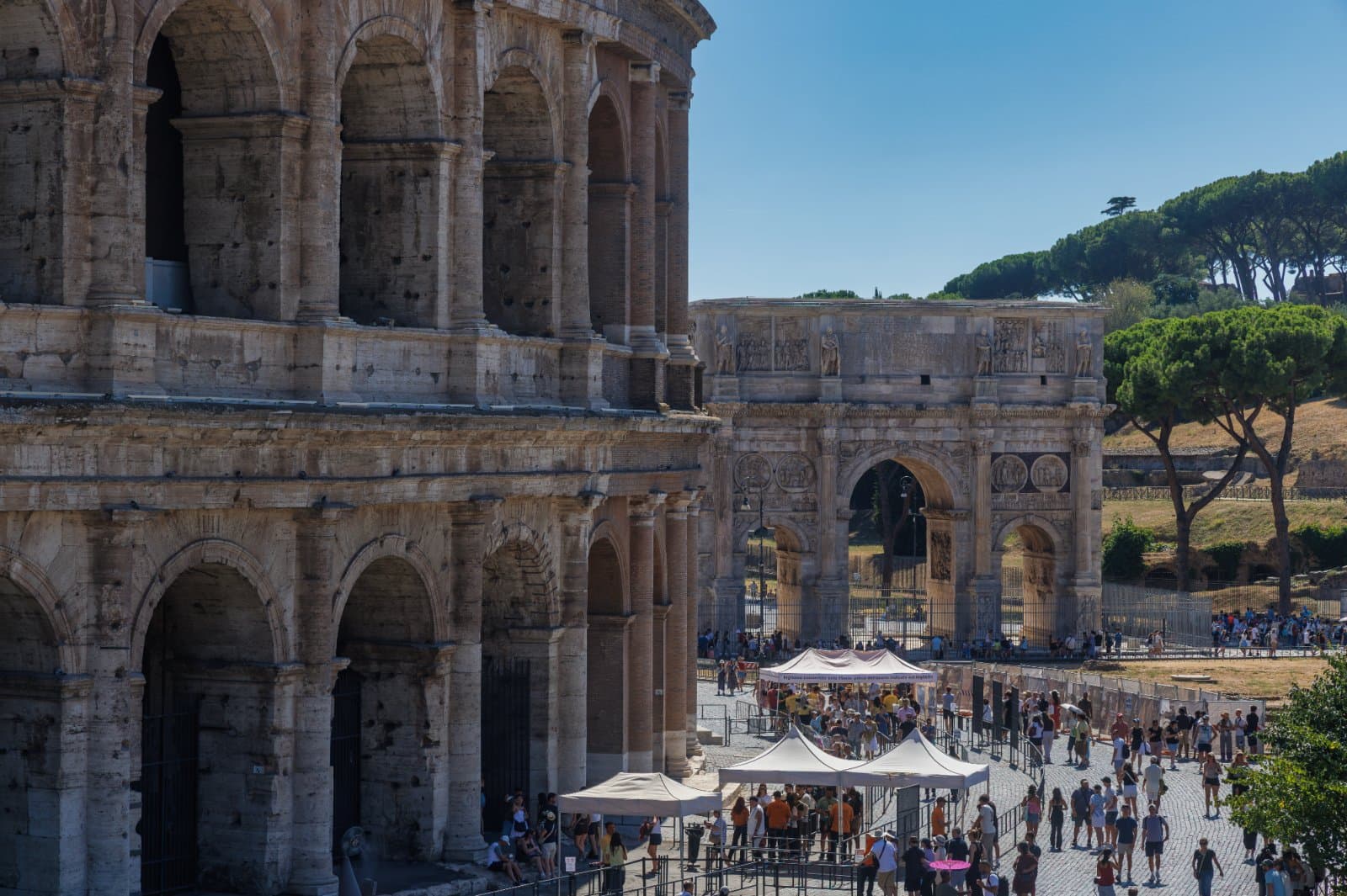 Coliseo y Arco de Constantino con visitantes en el área arqueológica